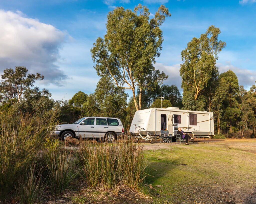 A,Mature,Woman,Sitting,Outside,A,Large,Modern,Caravan,And